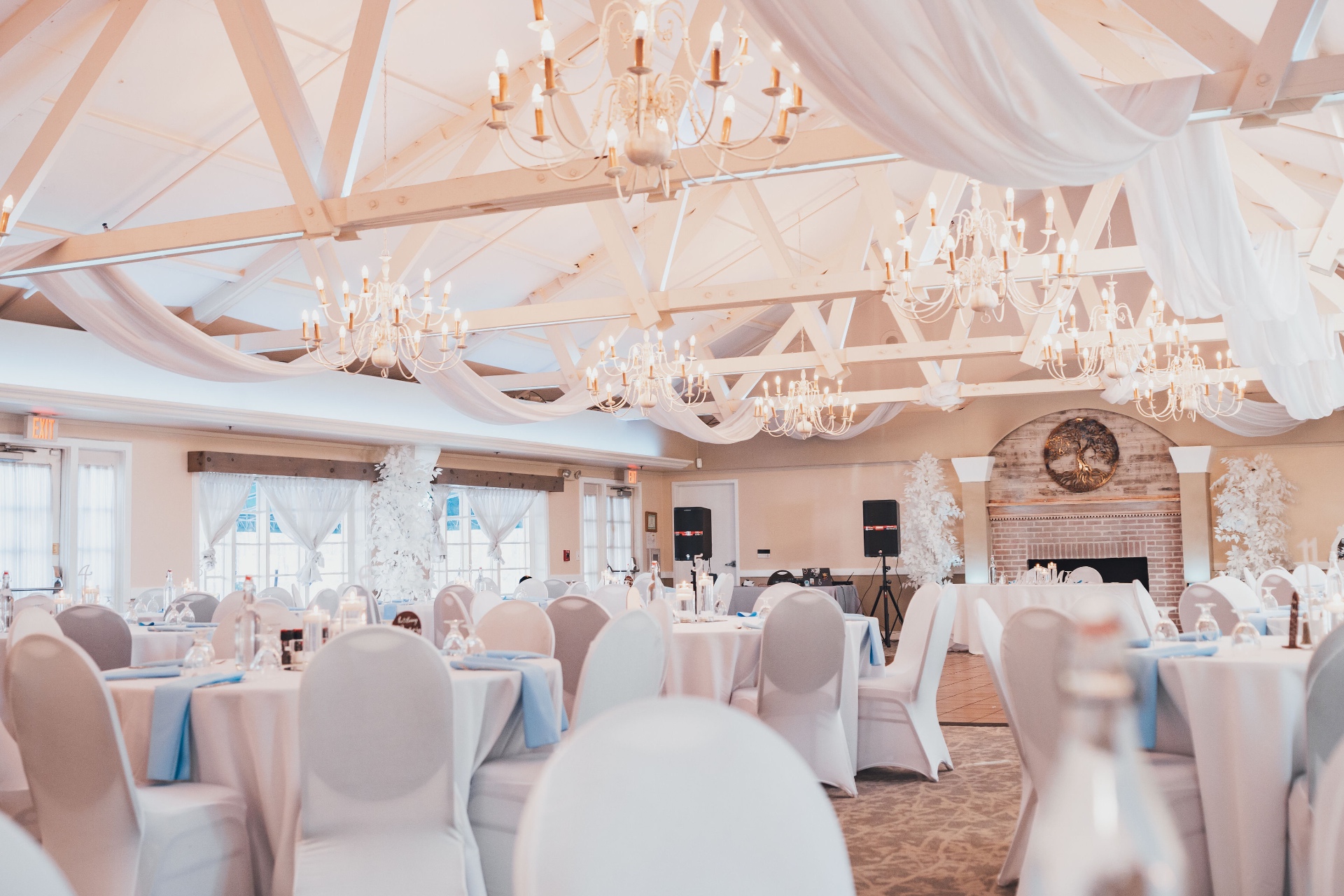 White chandelier ballroom reception with draping and candlelight