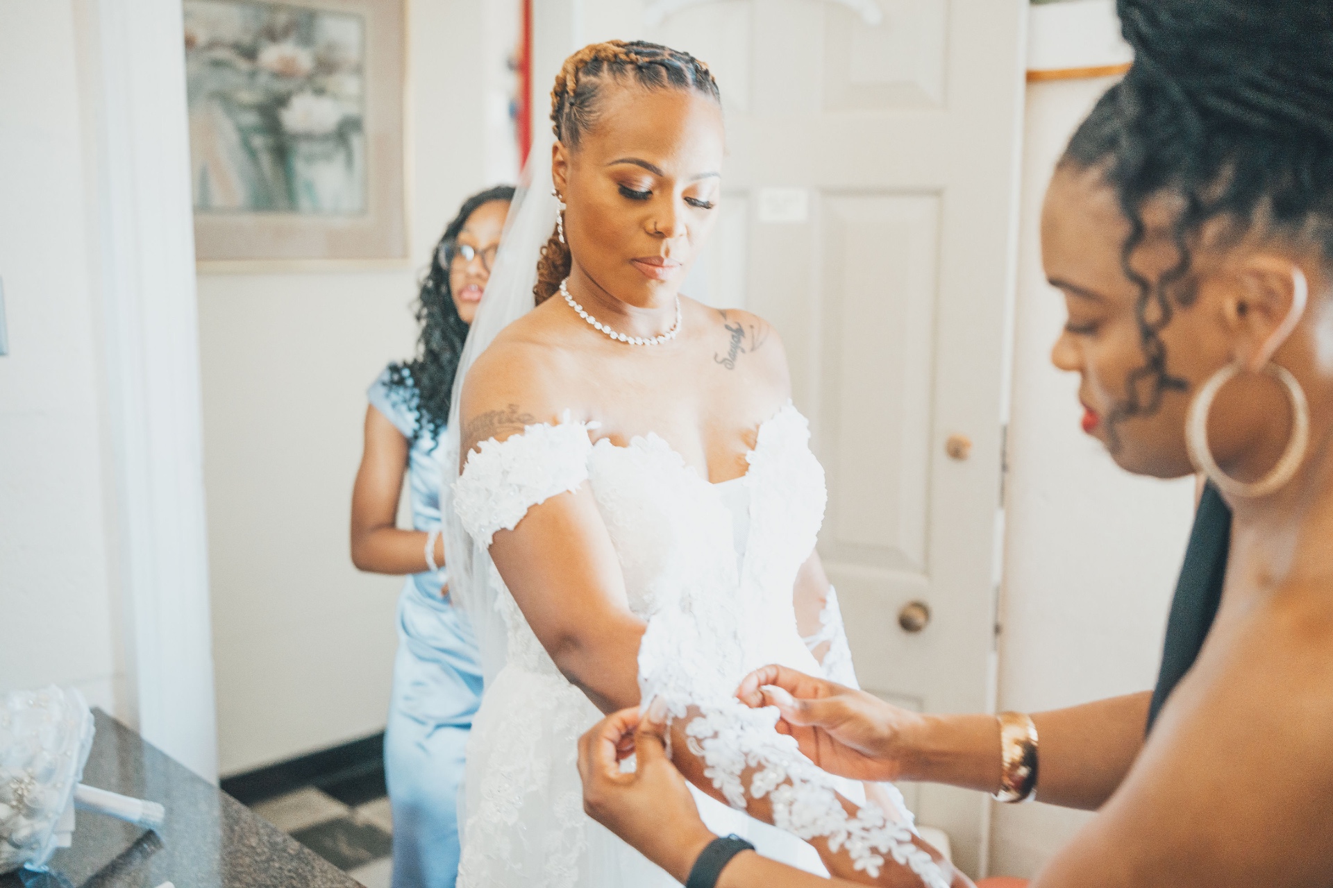 Bride in lace gown getting ready with her bridal party